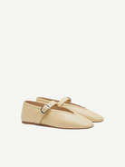 A pair of Stella Slipper Leather Shoes in beige custard leather, designed as Mary Jane flats with an elegant buckle on a thin strap, displayed against a plain white background.