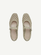 Top view of a pair of Mary Jane Woven Leather Shoes in beige, crafted from handwoven goatskin with a closed toe and an instep strap featuring buckle fastening, displayed against a plain white background.