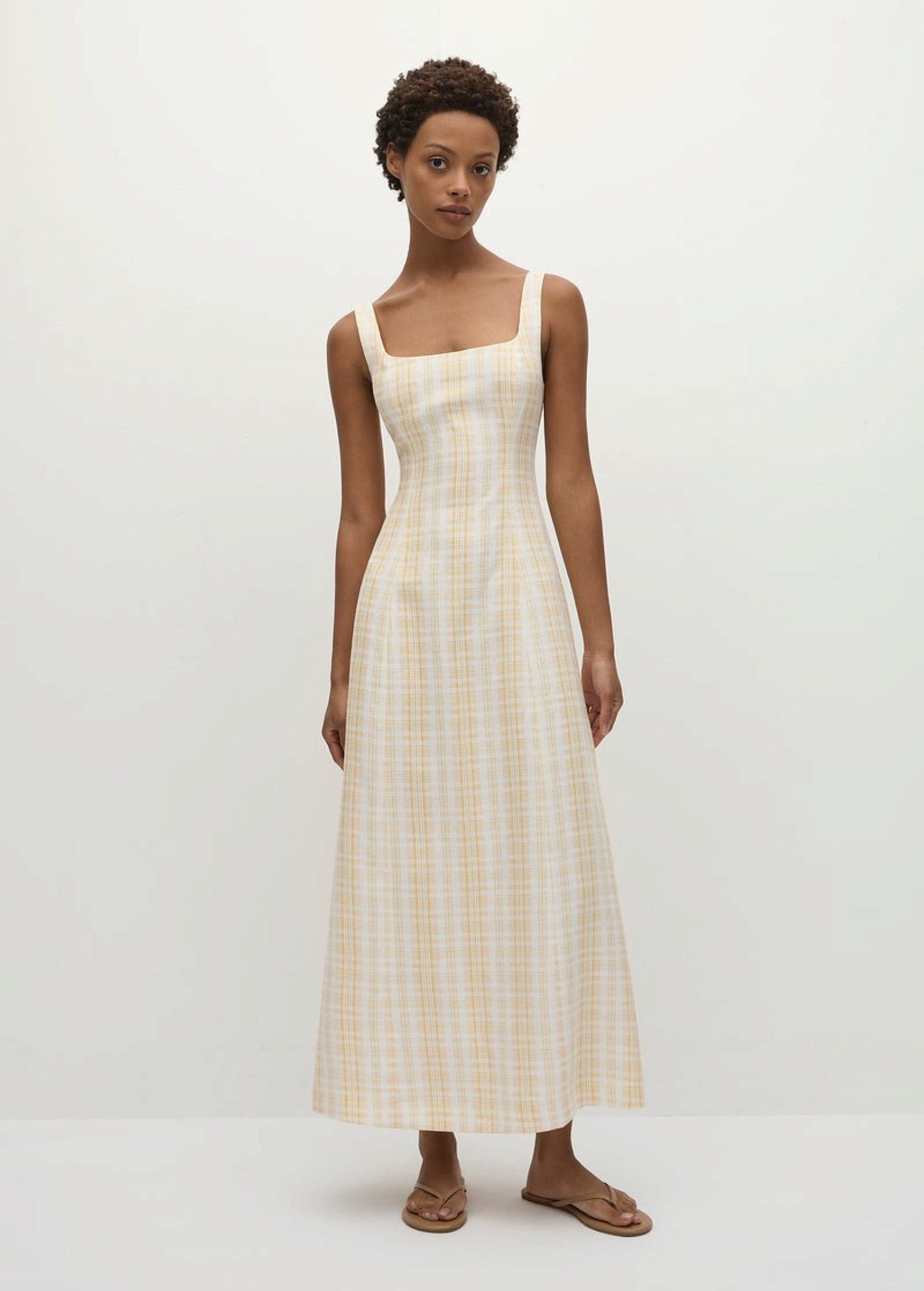 Model wearing a KABE SHOP INC Lenice midi dress in yellow and white plaid linen with a square neckline