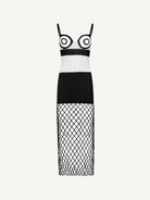 La Femme Dress: This black-and-white sleeveless dress features thin straps and bold circular patterns on the bodice, complemented by a solid black midsection. The skirt is crafted from crochet fabric with see-through diamond-patterned netting, creating an elegant yet modern look. Photographed against a plain white background.