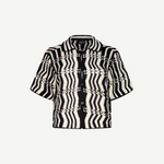 The Riviera Shirt is a black-and-white short-sleeve button-up summer shirt featuring a bold zigzag wavy pattern and a collar, displayed on a plain white background. This black-and-white crochet Riviera Shirt adds a unique textured twist to classic warm-weather style.