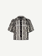 The Riviera Shirt is a black-and-white short-sleeve button-up summer shirt featuring a bold zigzag wavy pattern and a collar, displayed on a plain white background. This black-and-white crochet Riviera Shirt adds a unique textured twist to classic warm-weather style.