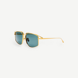 The Miranda Sunglasses feature an oversized, gold-plated frame and square blue-tinted lenses, displayed at an angle against a plain white background.