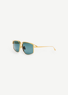 The Miranda Sunglasses feature an oversized, gold-plated frame and square blue-tinted lenses, displayed at an angle against a plain white background.