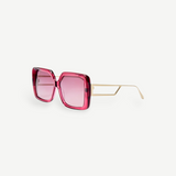 The Macy Sunglasses feature a square-shaped, oversized frame crafted from luxurious Italian acetate in bold pink, with light pink gradient lenses and elegant gold-plated temples and thin arms, showcased on a white background.