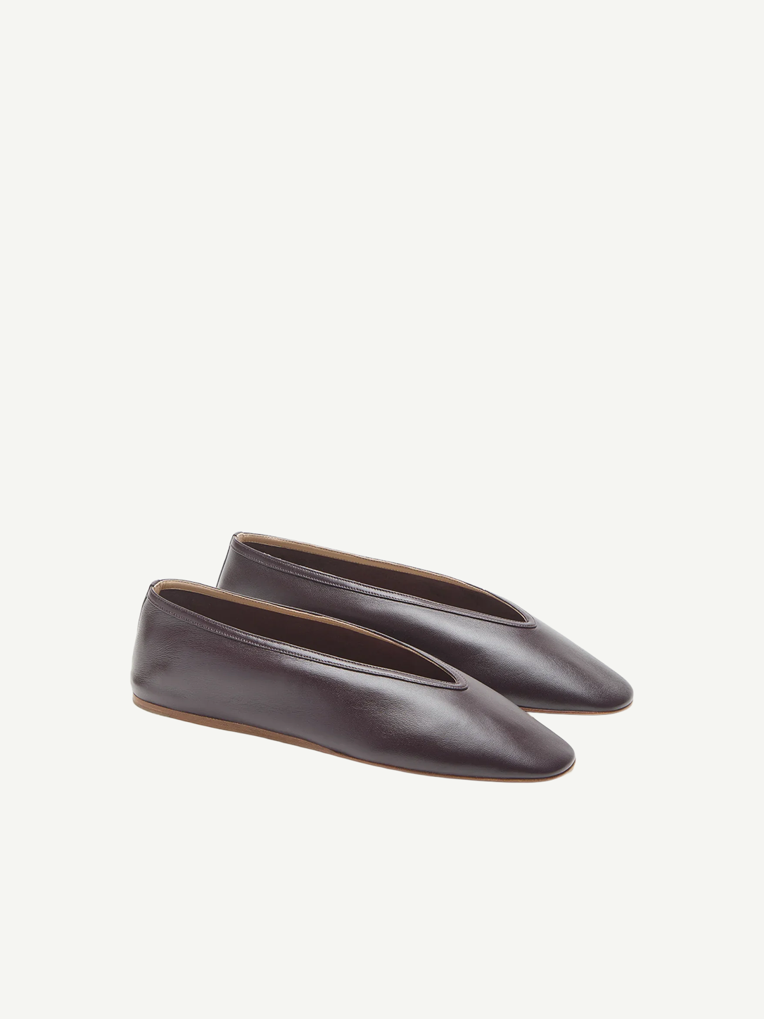 A pair of Luna Slipper Shoes in dark brown leather, featuring a minimalist design with subtle leather detailing and almond-shaped toes, displayed against a plain white background.