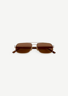 Evangeline sunglasses feature a rectangular gold metal frame with brown tinted lenses and slim arms, offering UV protection and crafted from durable stainless steel, presented on a white background facing forward.