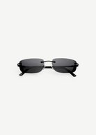 Paris sunglasses feature a rimless rectangle design with dark gray lenses and thin black arms, displayed against a plain white background. Inspired by iconic 2000s style, Paris offers reliable UV protection for everyday wear.