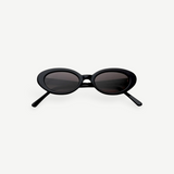 A pair of Sylvie oval sunglasses in black, featuring dark lenses and showcased on a plain white background—ideal for elevating any outfit with a touch of vintage suit-inspired elegance.