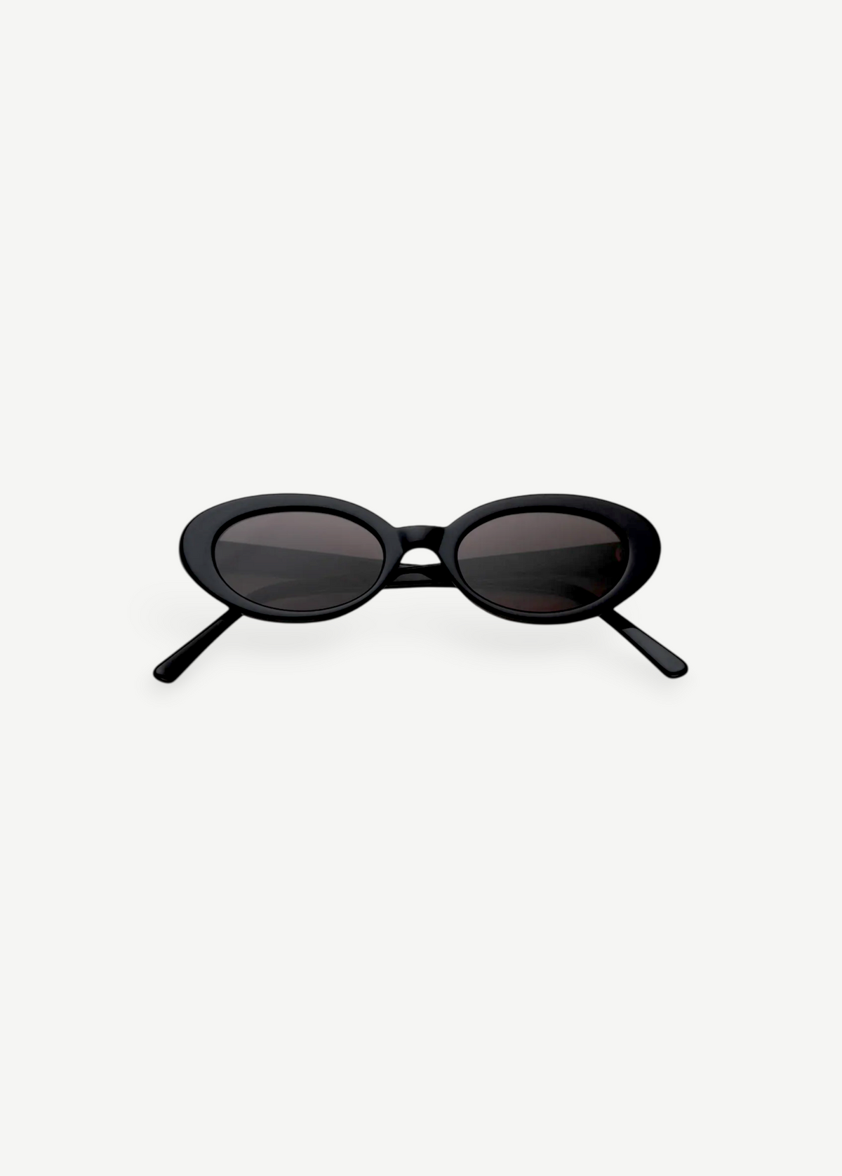 A pair of Sylvie oval sunglasses in black, featuring dark lenses and showcased on a plain white background—ideal for elevating any outfit with a touch of vintage suit-inspired elegance.