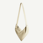 Introducing the Vancouver Sling Bag: a minimalist cream-colored sculptural shoulder bag with a single long strap, crafted from smooth, soft nappa leather and showcasing a subtle angled design, photographed on a plain white background.