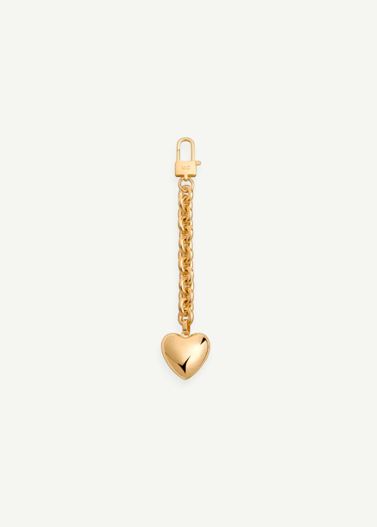 The Heart Bag Charm features a shiny, puffy heart pendant hanging from a 14KT gold plated chain, adding timeless elegance to any accessory. Shown on a plain white background, this piece channels the chic style of a Martha Calvo pendant.