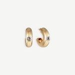 The Kaia Earrings are a pair of small, chunky gold plated hoops, each featuring a single round white gemstone accented with subtle crystal detailing, shown against a plain white background.