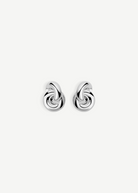 The Rhodium Amina Earrings are featured on a plain white background, showcasing an intricate interwoven knot design with a polished, shiny finish and a secure pierced back.