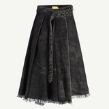 Introducing the Midi Kilt Skirt with Buckle Fastening: a black acid wash, knee-length skirt featuring pleats, an uneven raw hem with frayed edges, and a matching belt tied at the waist. The washed, slightly faded denim lends effortless edge to this distinctive midi skirt.