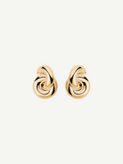 The Amina Earrings are displayed on a plain white background. These elegant earrings feature a gold-plated, intertwined looped design with a smooth, polished finish and a classic pierced back for secure wear.