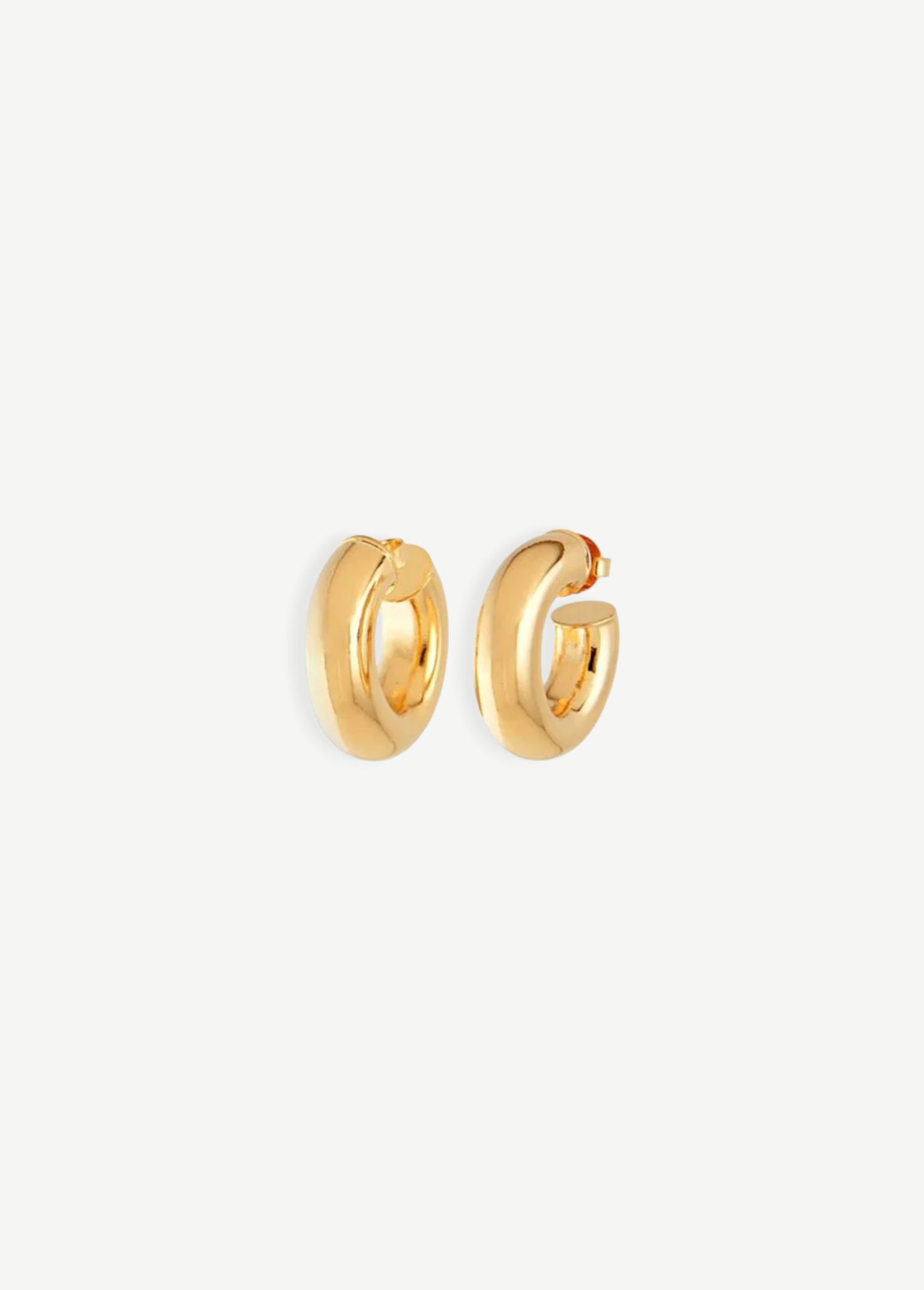 A pair of Donut Pierced Hoops, small and chunky gold earrings crafted from 14kt gold plate with a 1-inch diameter, displayed against a plain white background.