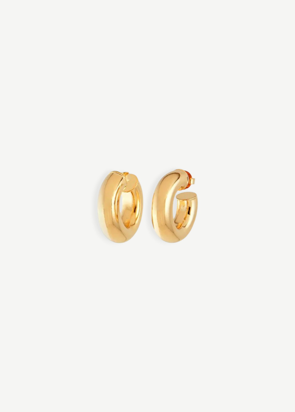 A pair of Donut Pierced Hoops, small and chunky gold earrings crafted from 14kt gold plate with a 1-inch diameter, displayed against a plain white background.