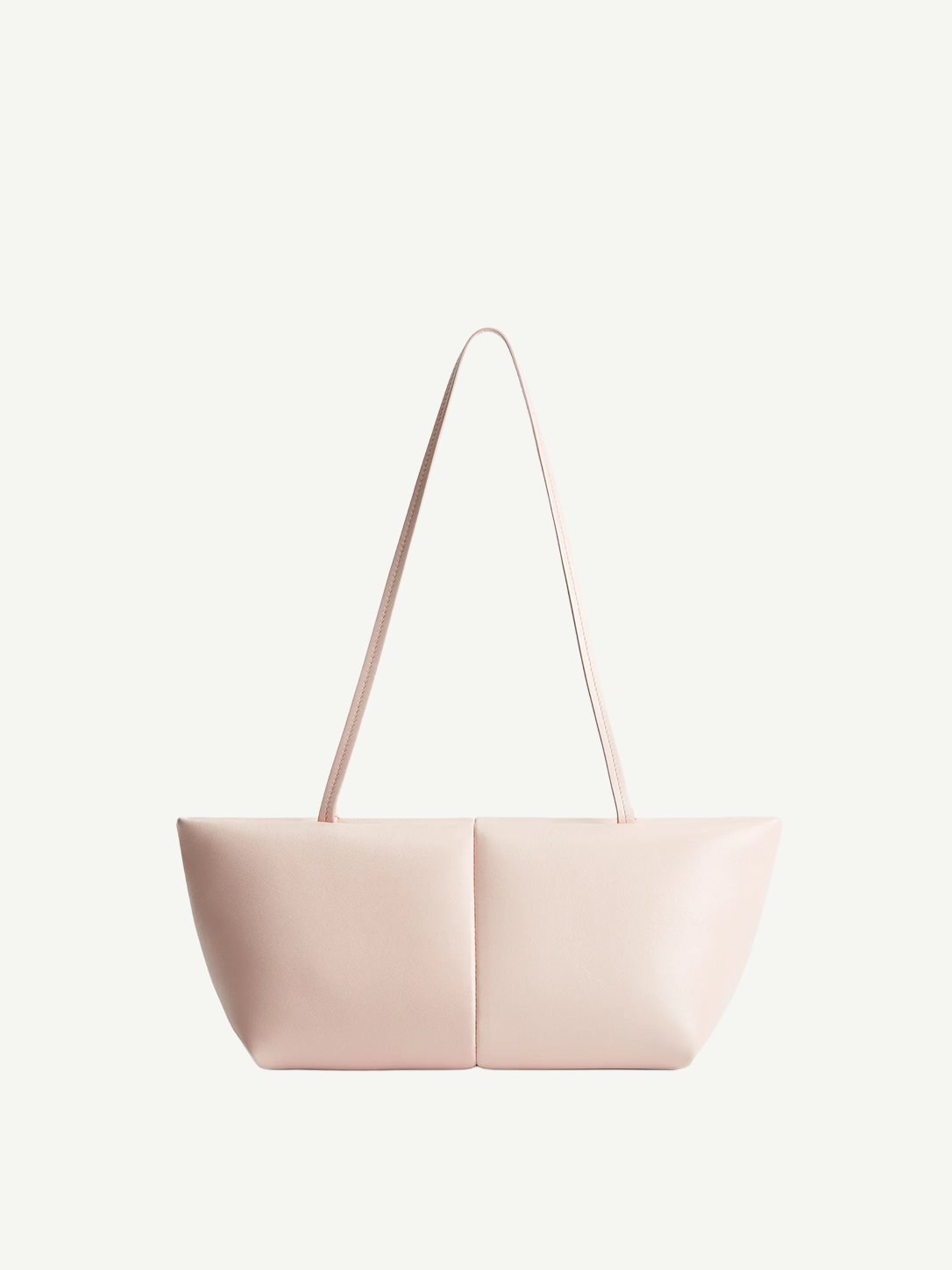 The Boulevard Sling Bag is a light pink, minimalist padded handbag featuring two symmetrical panels and thin straps, displayed on a plain white background.