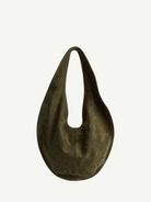 The Market Tote Bag is a dark olive green, crescent-shaped suede bag featuring a single wide strap, shown against a plain white background.