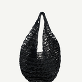 The Market Net Bag is a black, hand-crocheted shoulder bag featuring an open, net-like pattern and a rounded shape, shown against a plain white background.