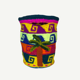 Introducing the Palmeras Bag Sac: a vibrant, handwoven basket bag adorned with geometric patterns and a distinctive palm tree motif on the front. Featuring bold stripes in yellow, green, purple, pink, and blue, this colorful handmade bag is both eye-catching and practical.