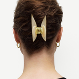 KABE SHOP INC Midi Heirloom hair claw in cream Italian acetate worn in a bun on a woman with gold hoop earrings