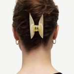 KABE SHOP INC Midi Heirloom hair claw in cream Italian acetate worn in a bun on a woman with gold hoop earrings