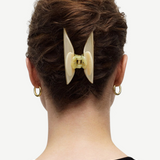KABE SHOP INC Midi Heirloom hair claw in cream Italian acetate worn in a bun on a woman with gold hoop earrings