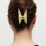 KABE SHOP INC Midi Heirloom hair claw in cream Italian acetate worn in a bun on a woman with gold hoop earrings