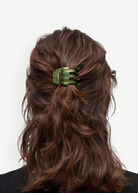 KABE SHOP INC mini claw hair clip in green striped Italian bio-acetate worn in wavy brown hair