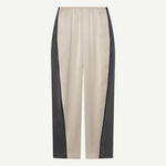 Beige Zoela Pants featuring black side panels, an elastic waistband, and a relaxed, wide barrel-leg silhouette, showcased against a plain white background.