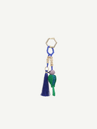 The Hummingbird Keychain features a gold hexagonal ring, blue beads, cube letter beads, a blue tassel, and a green woven chili pepper charm—each element reflecting exquisite Colombian craftsmanship in every detail.