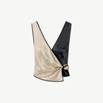 Introducing the Aisling Top: a sleeveless, color-block design crafted from luxurious slip satin. This top features a deep V-neckline, with the left half in striking beige and the right half in bold black, elegantly finished with a knot detail at the side.
