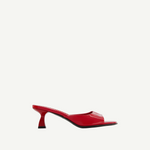 The Dona Mule is a red, open-toe heeled mule pump featuring a sleek design, low curved heel, and glossy finish, expertly crafted in Italy and showcased against a plain white background.