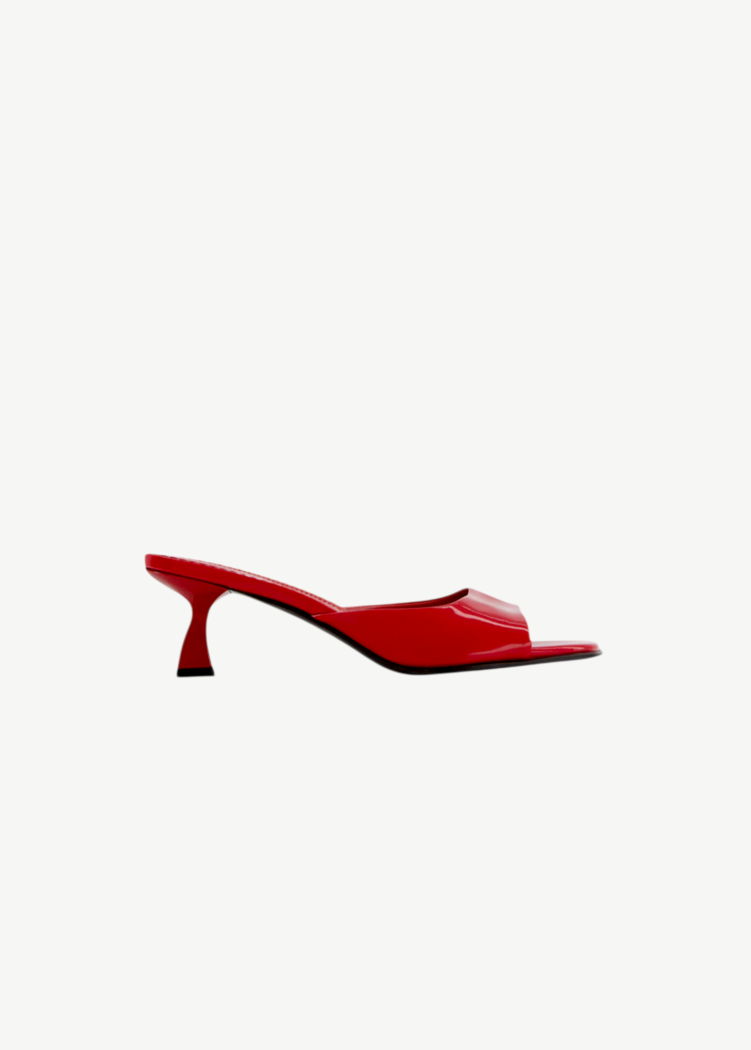 The Dona Mule is a red, open-toe heeled mule pump featuring a sleek design, low curved heel, and glossy finish, expertly crafted in Italy and showcased against a plain white background.
