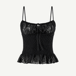Introducing the Slip Top: a black lace camisole featuring adjustable shoulder straps, a ruched bodice, and a ruffled hem. This elegant Slip Top showcases a decorative bow at the neckline and a delicate floral lace pattern—perfect for pairing with ruffle pants or your favorite jeans.
