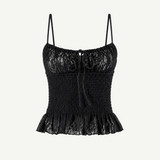 Introducing the Slip Top: a black lace camisole featuring adjustable shoulder straps, a ruched bodice, and a ruffled hem. This elegant Slip Top showcases a decorative bow at the neckline and a delicate floral lace pattern—perfect for pairing with ruffle pants or your favorite jeans.