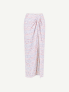 The Sarong Skirt is a long, high-waisted piece with a pastel multicolor speckled pattern. It features a straight silhouette, ankle-length hem, and is accented by a side drape and gathered waist detail—perfect for effortless beachwear.