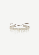 N° 675 Silver Bracelet featuring a delicate design with dangling chain fringe and an adjustable braided clasp, offering a subtle touch perfect for everyday wear, displayed against a plain white background.