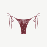 Praia Bottom—maroon bikini bottom with a white paisley bandana print, crafted from eco terry fabric and featuring adjustable side tie straps—displayed on a white background.