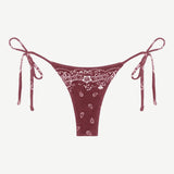 Praia Bottom—maroon bikini bottom with a white paisley bandana print, crafted from eco terry fabric and featuring adjustable side tie straps—displayed on a white background.