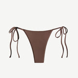 The Praia Bottom, a brown triangle bikini bottom featuring high-cut legs and adjustable side ties, is crafted from eco-friendly ECONYL® regenerated nylon and displayed on a plain white background.