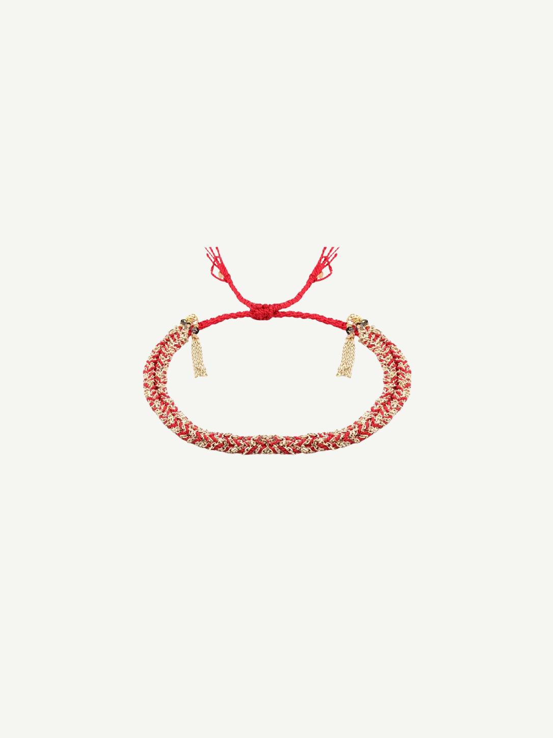 The N° 183 Braided Bracelet is crafted from amethyst silk intricately braided in red and gold, adorned with gold charms at each end and finished with an adjustable red cord, showcasing a radiant yellow gold finish. It is displayed on a plain white background.