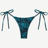 Praia Bottom in blue and black tiger print, an adjustable tie bikini bottom crafted from recycled polyamide for eco-friendly swimwear, displayed on a white background.