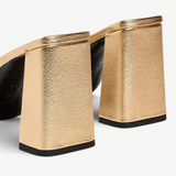 Sloane Heel metallic gold mules with block heels and black outsoles in a timeless silhouette.