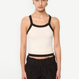 Model wearing KABE SHOP INC Tovi tank top in cream stretch cotton rib with black bonded straps and trim