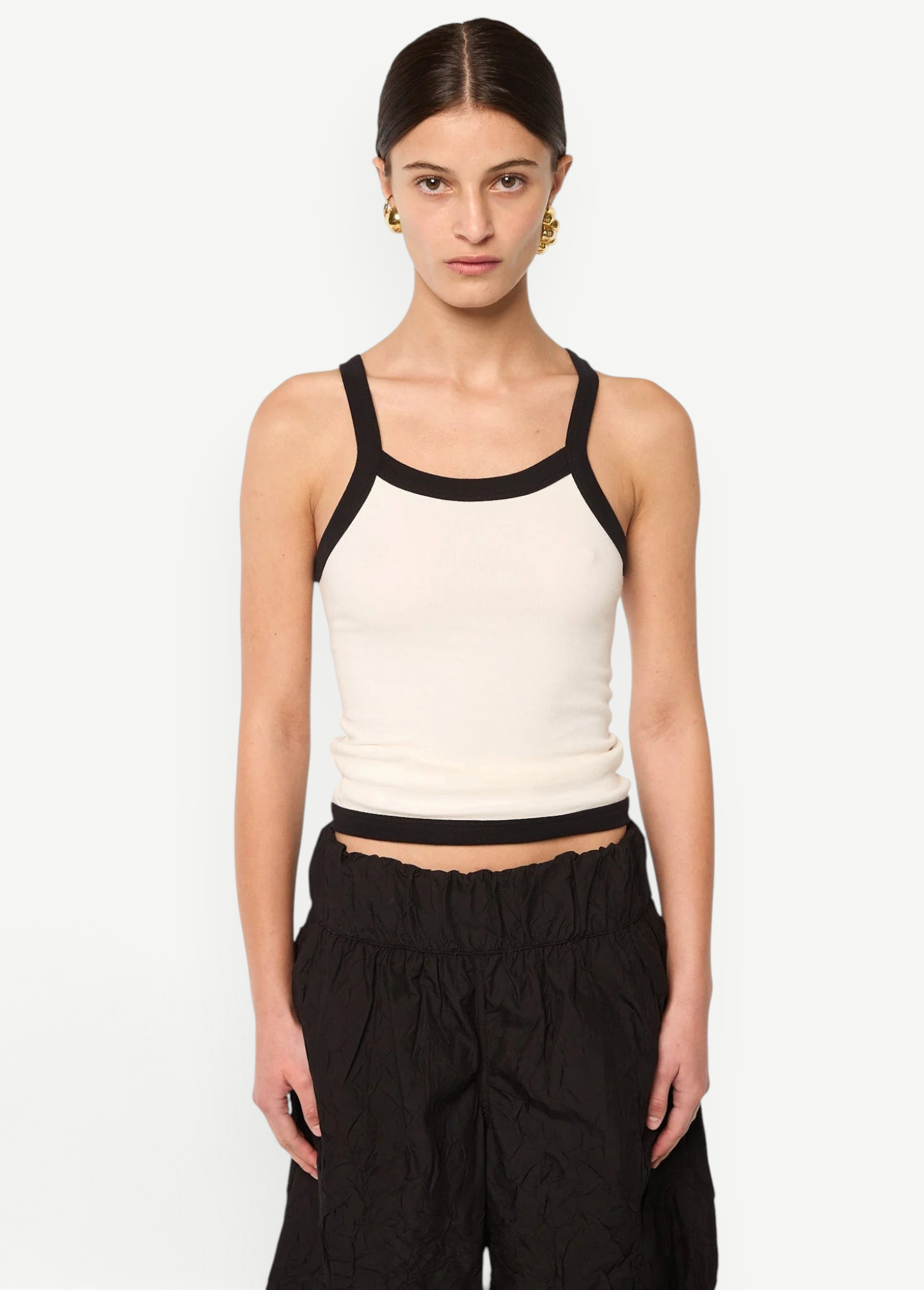 Model wearing KABE SHOP INC Tovi tank top in cream stretch cotton rib with black bonded straps and trim
