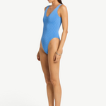 KABE SHOP INC Mara blue textured one-piece swimsuit with V-neckline and high-cut leg worn by a model, side view