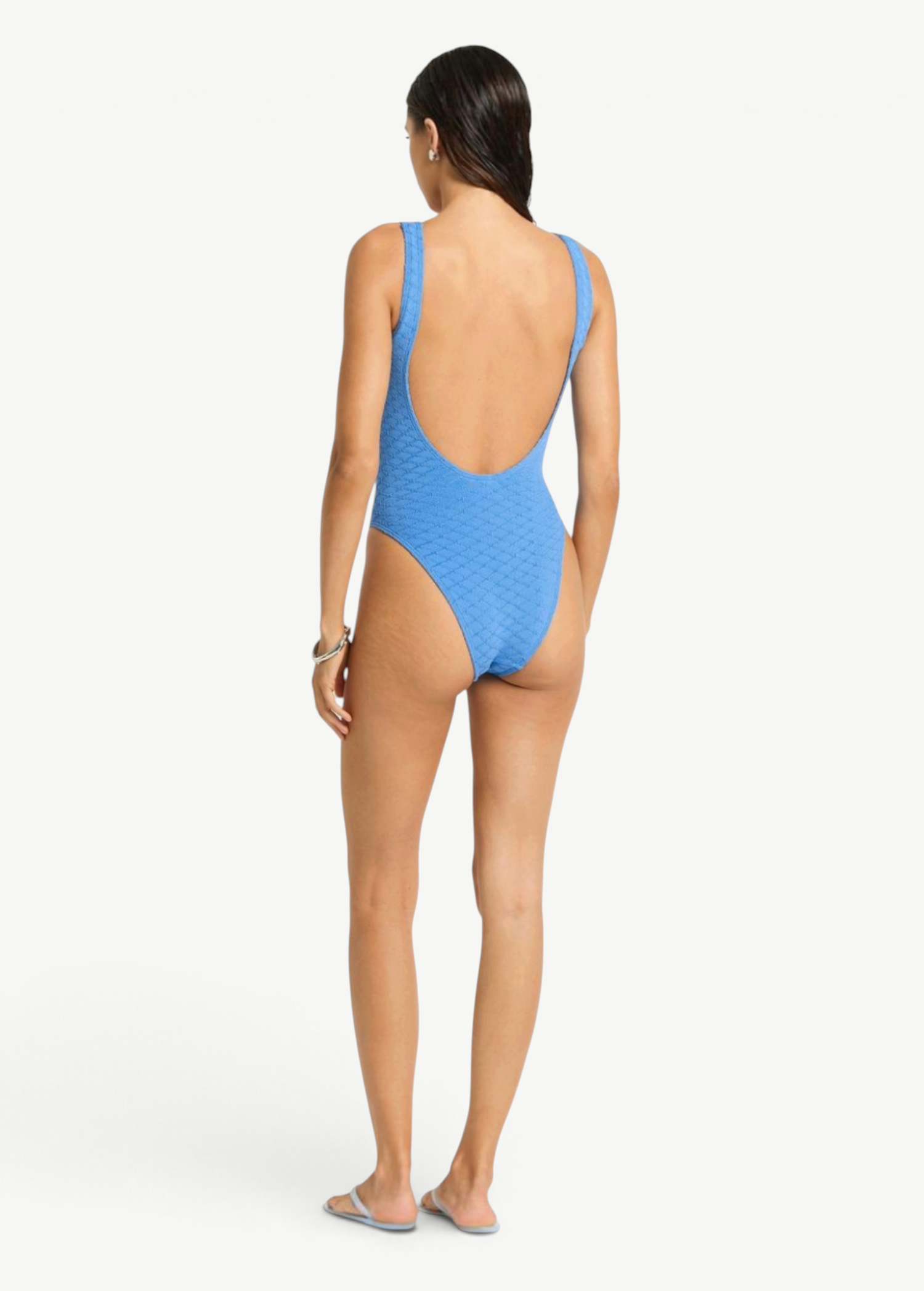 KABE SHOP INC Mara blue textured one-piece swimsuit with a low scoop back and high-cut leg on a model